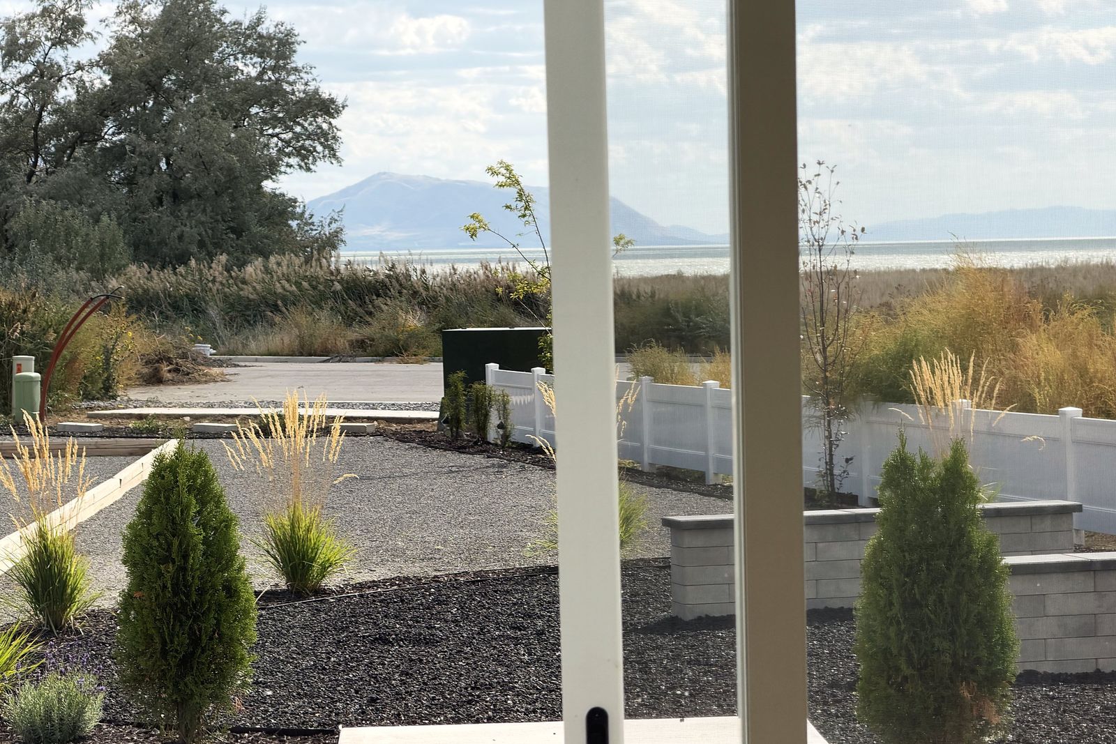 Backyard planting beds with the lake and mountains beyond the fence