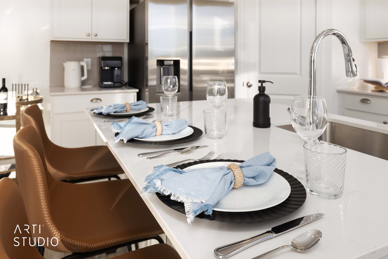 Kitchen island set with plates, glassware and blue napkins