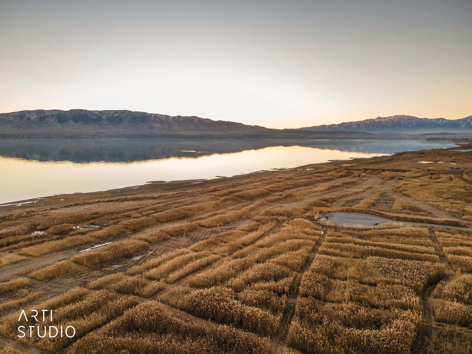 Aerial view of Utah Lake at sunset with wetlands in the foreground