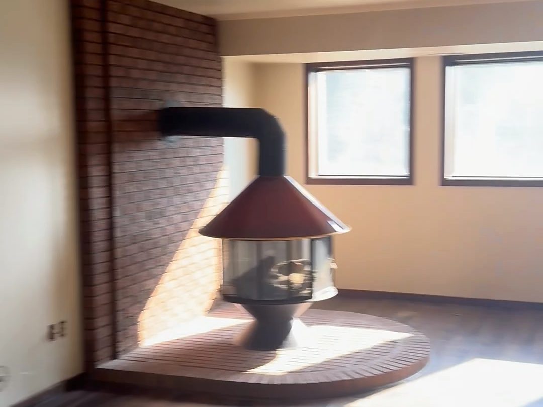 Before: Lower-level family room, the freestanding fireplace kept