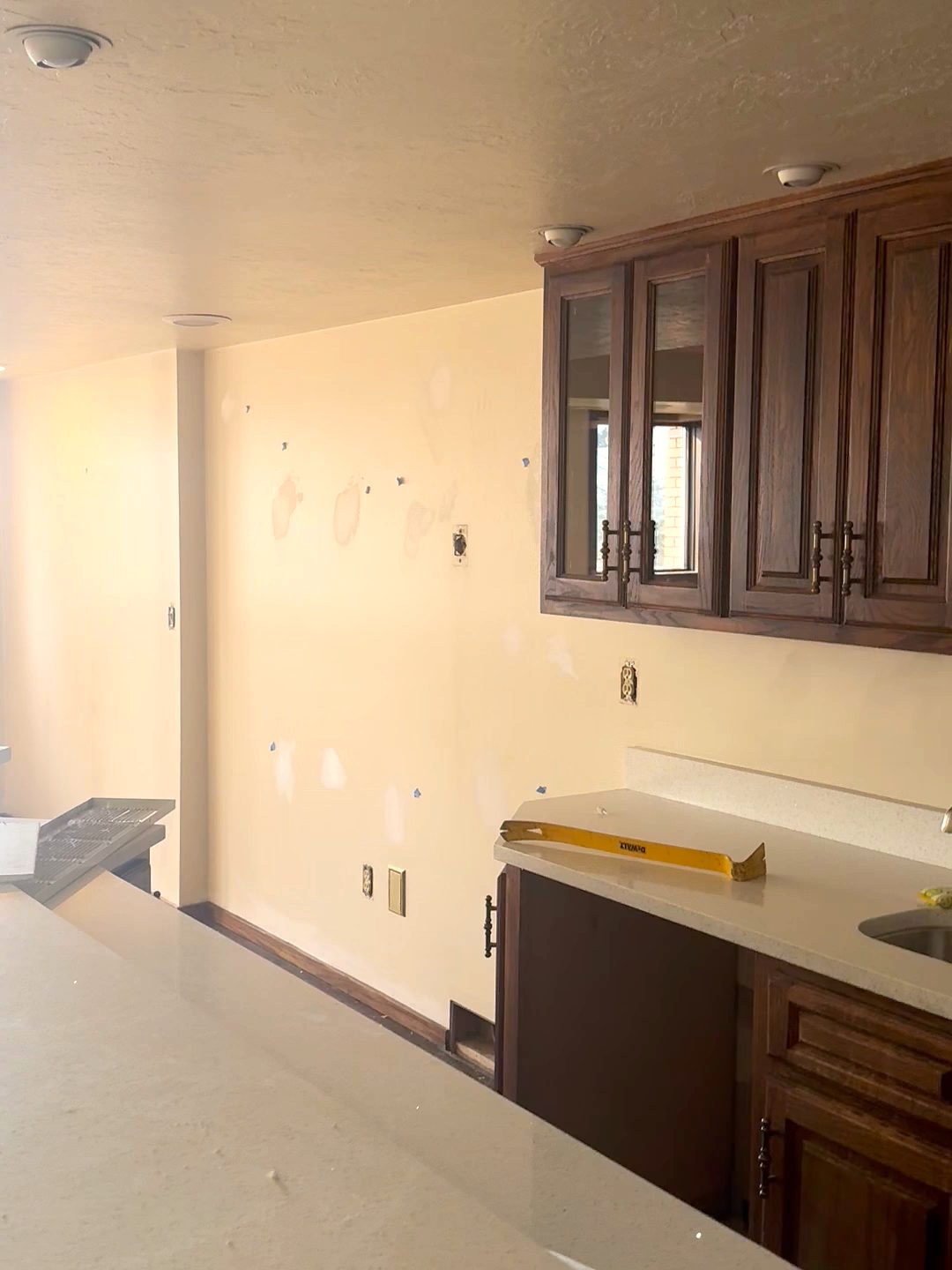 Lower-level kitchenette with dark wood cabinets before renovation