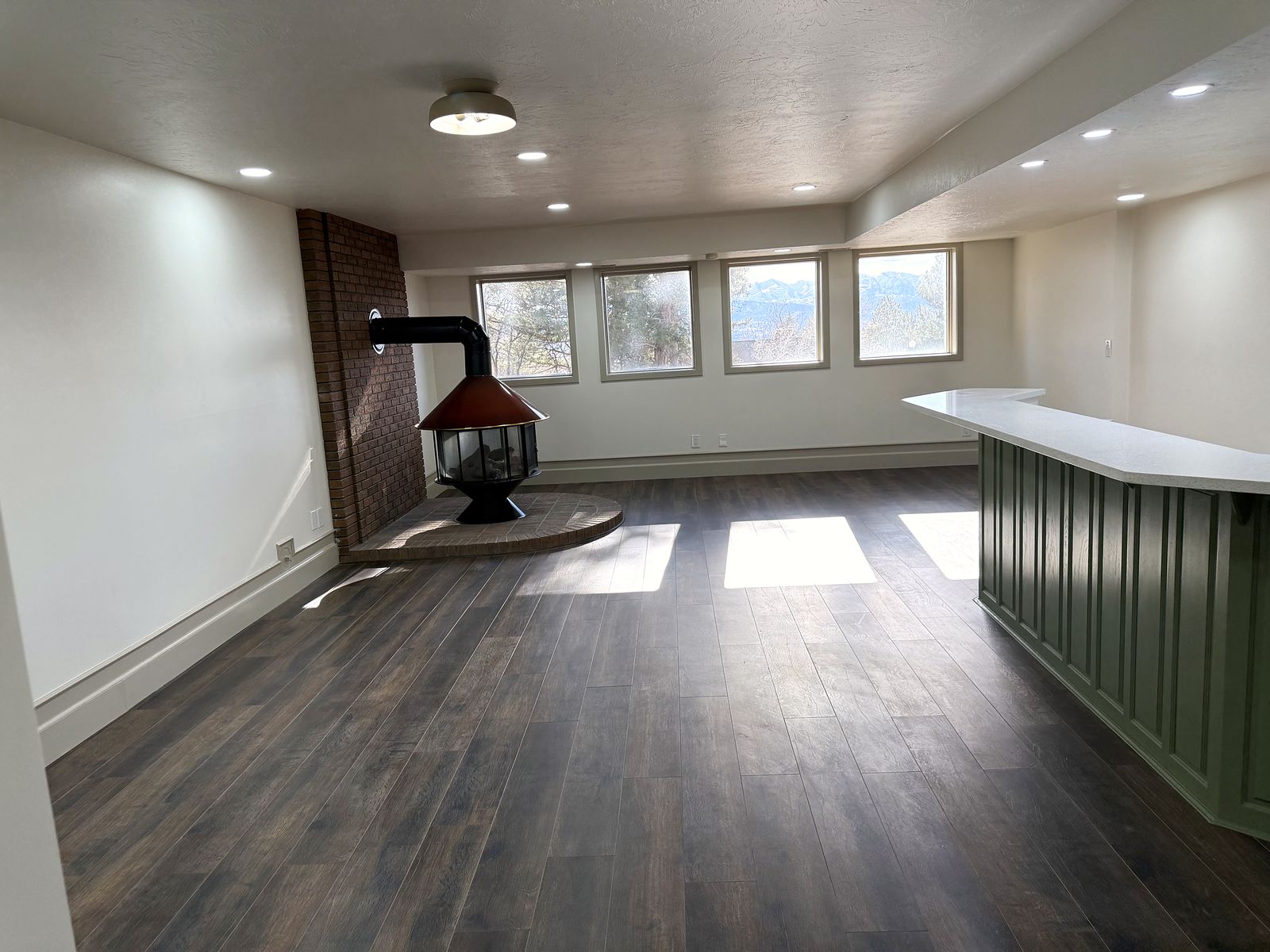After: Lower-level family room, the freestanding fireplace kept
