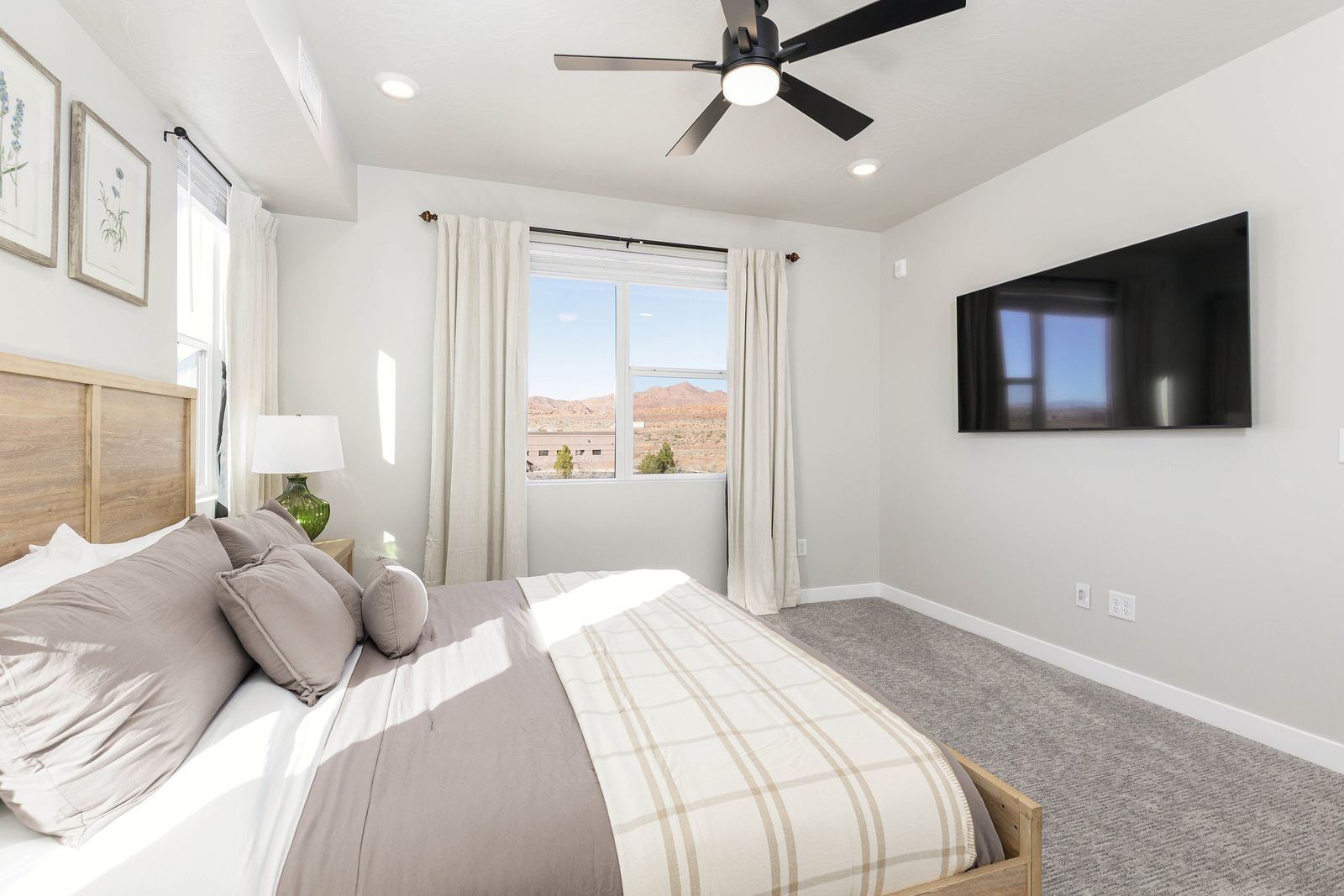 Bedding detail with a plaid throw and a window to the desert