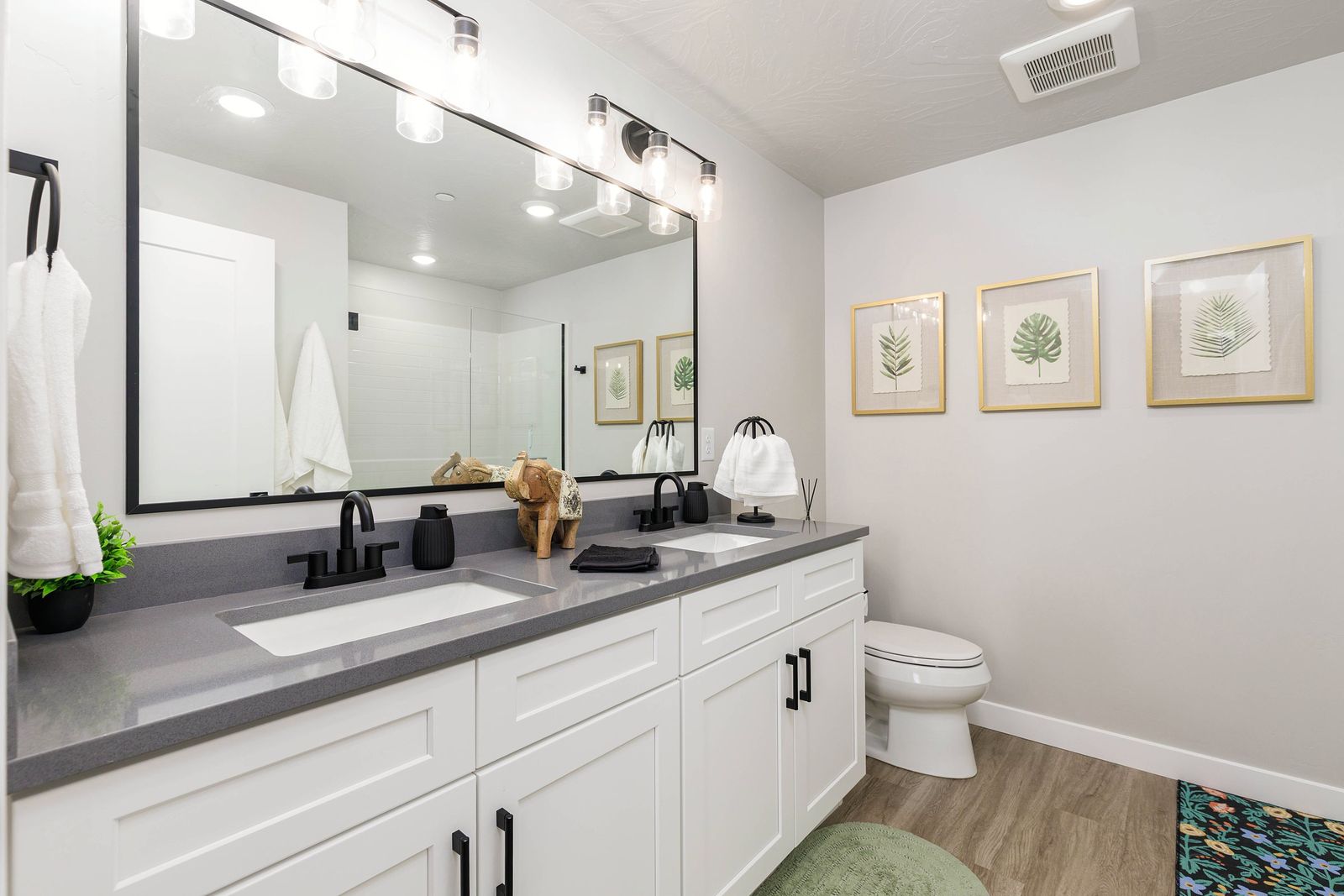 Double vanity with botanical prints and black fixtures