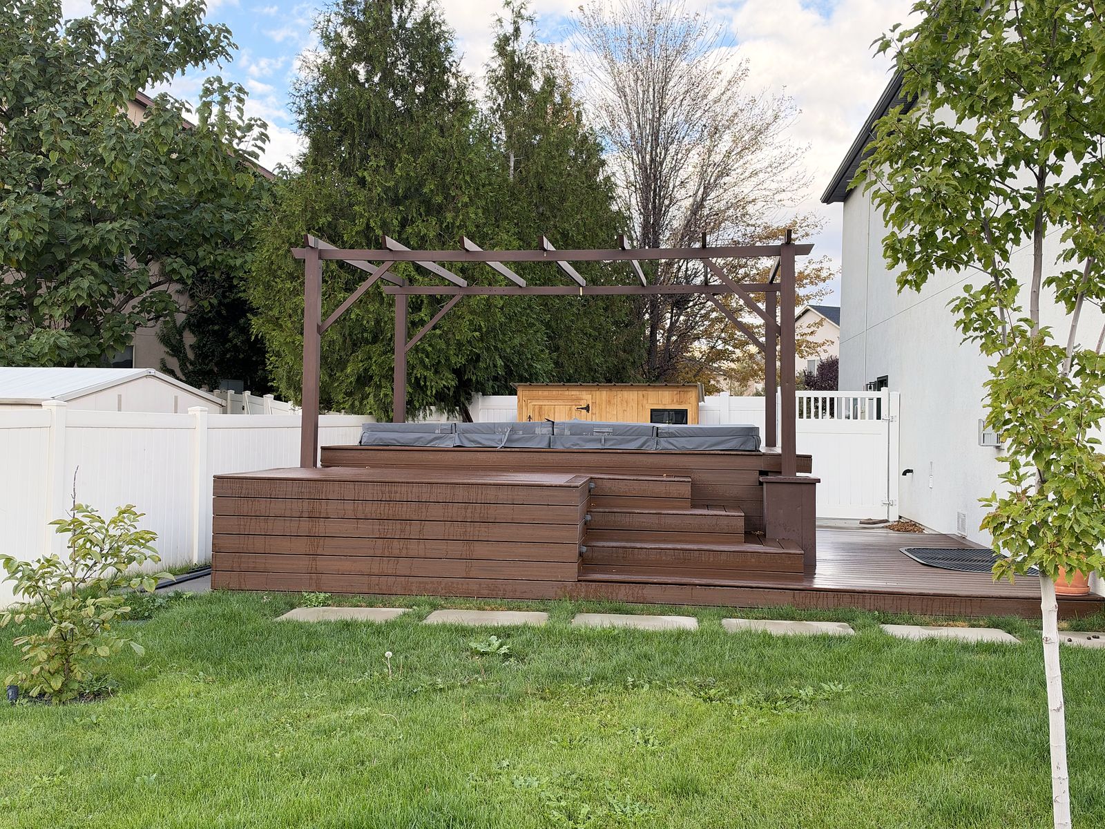 Side view of the elevated deck and pergola with the hot tub set into the upper level